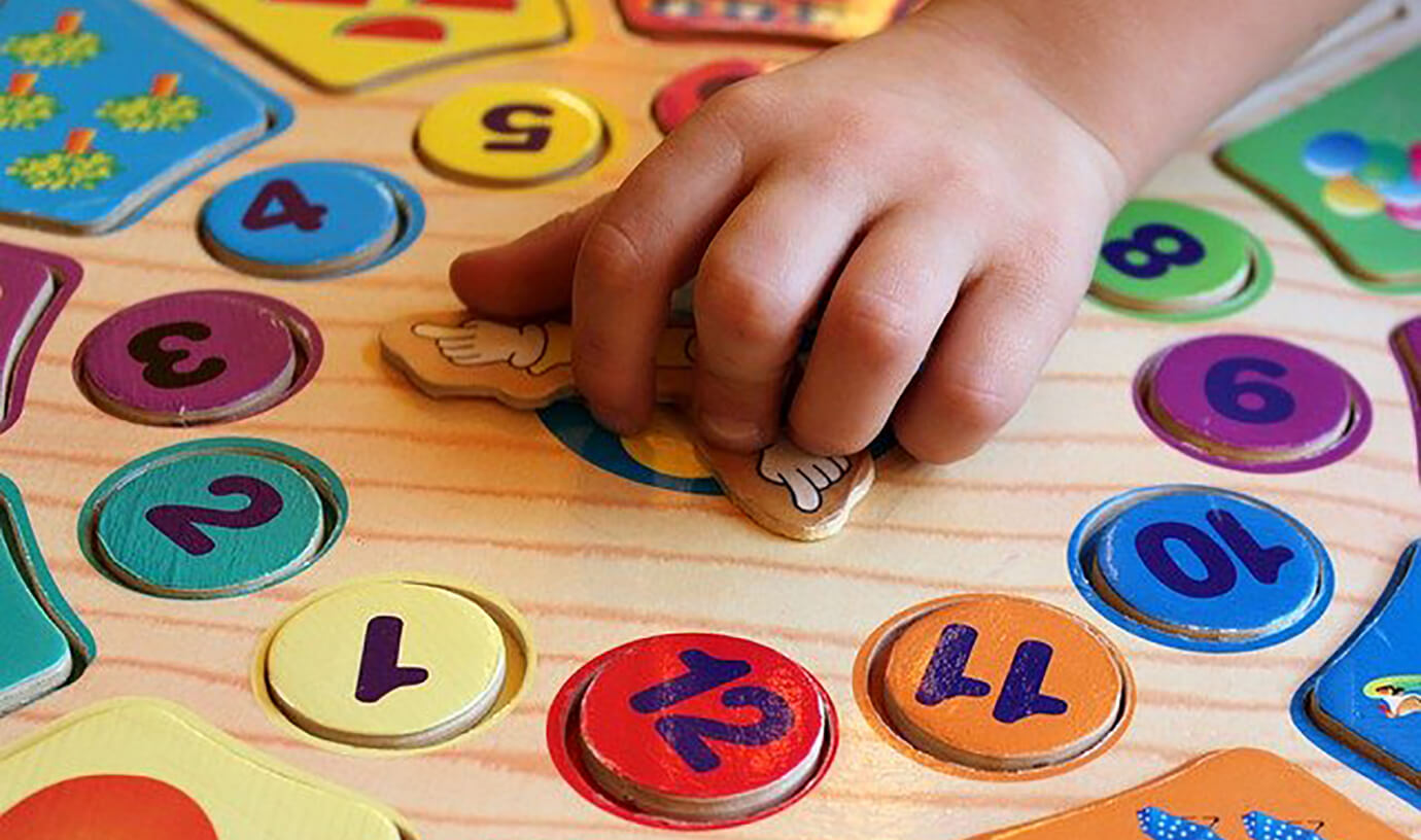 A child&#x27;s hand playing with a numbers game