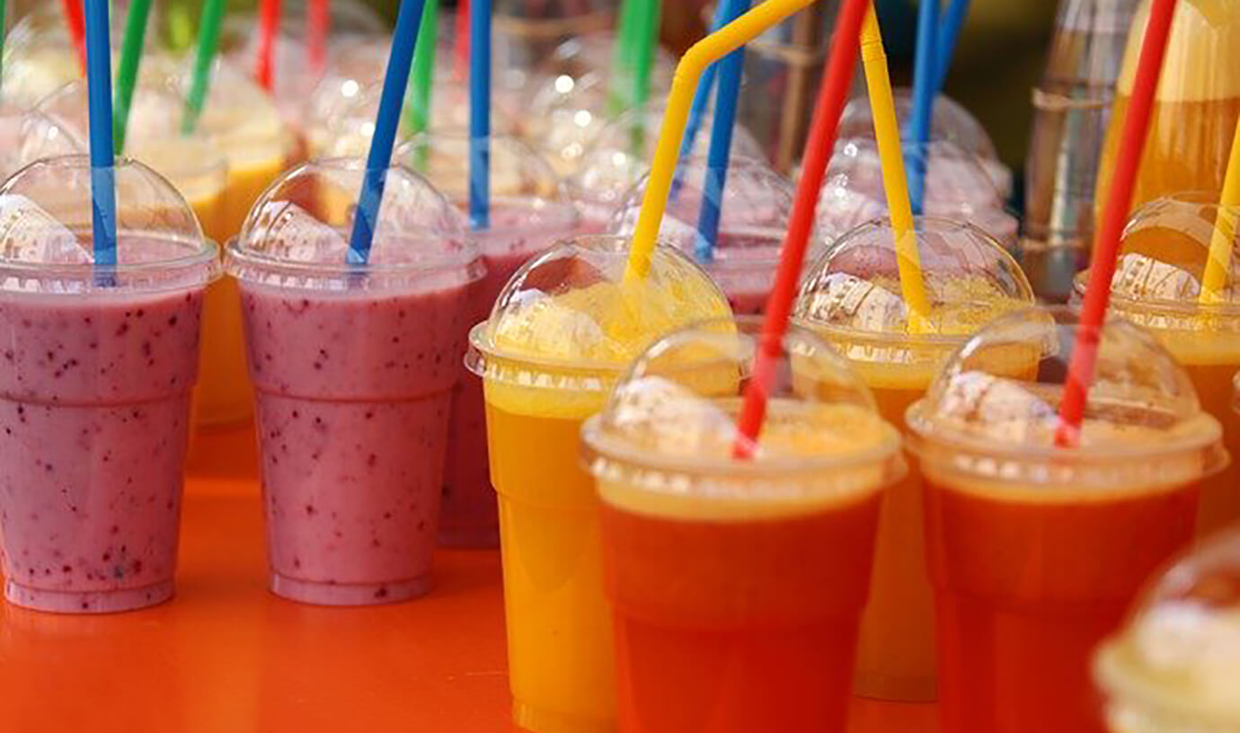Fruit drinks in plastic cups with straws
