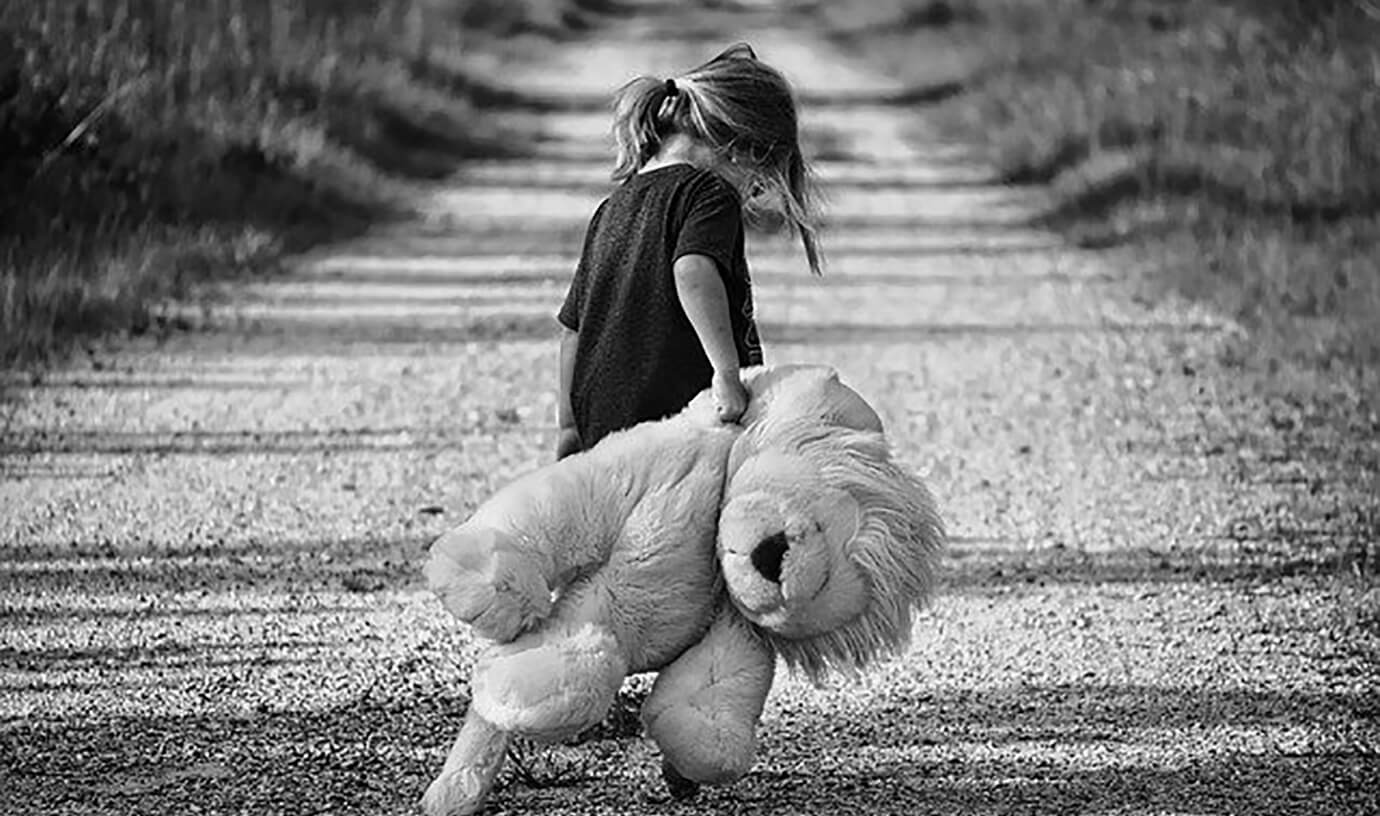 Sad girl holding teddy bear